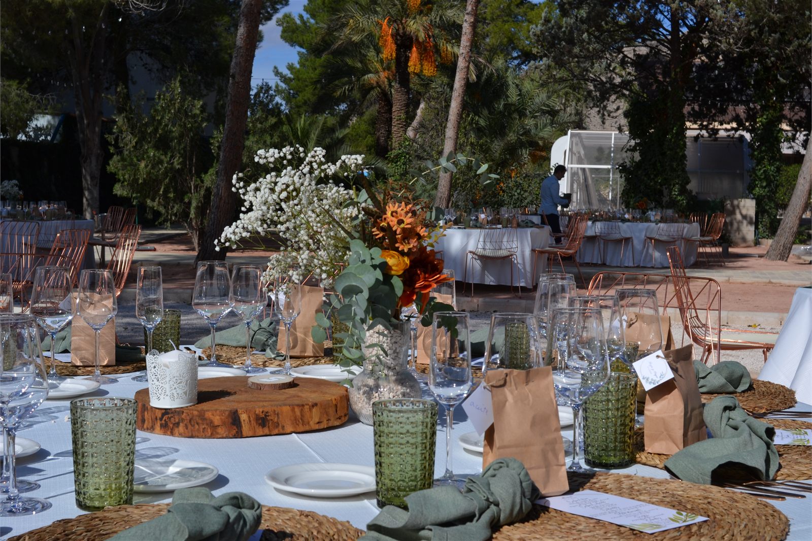 Mesa de banquete de boda al aire libre con cristaleria, flores y montaje elegante